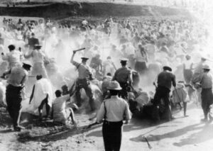 Black and white image of police beating up protestors during the Soweto Uprising of 16 June 1976.